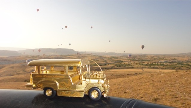 Golden jeepney with hot air balloons over Cappadocia