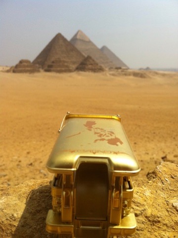 Golden jeepney facing the Pyramids of Giza