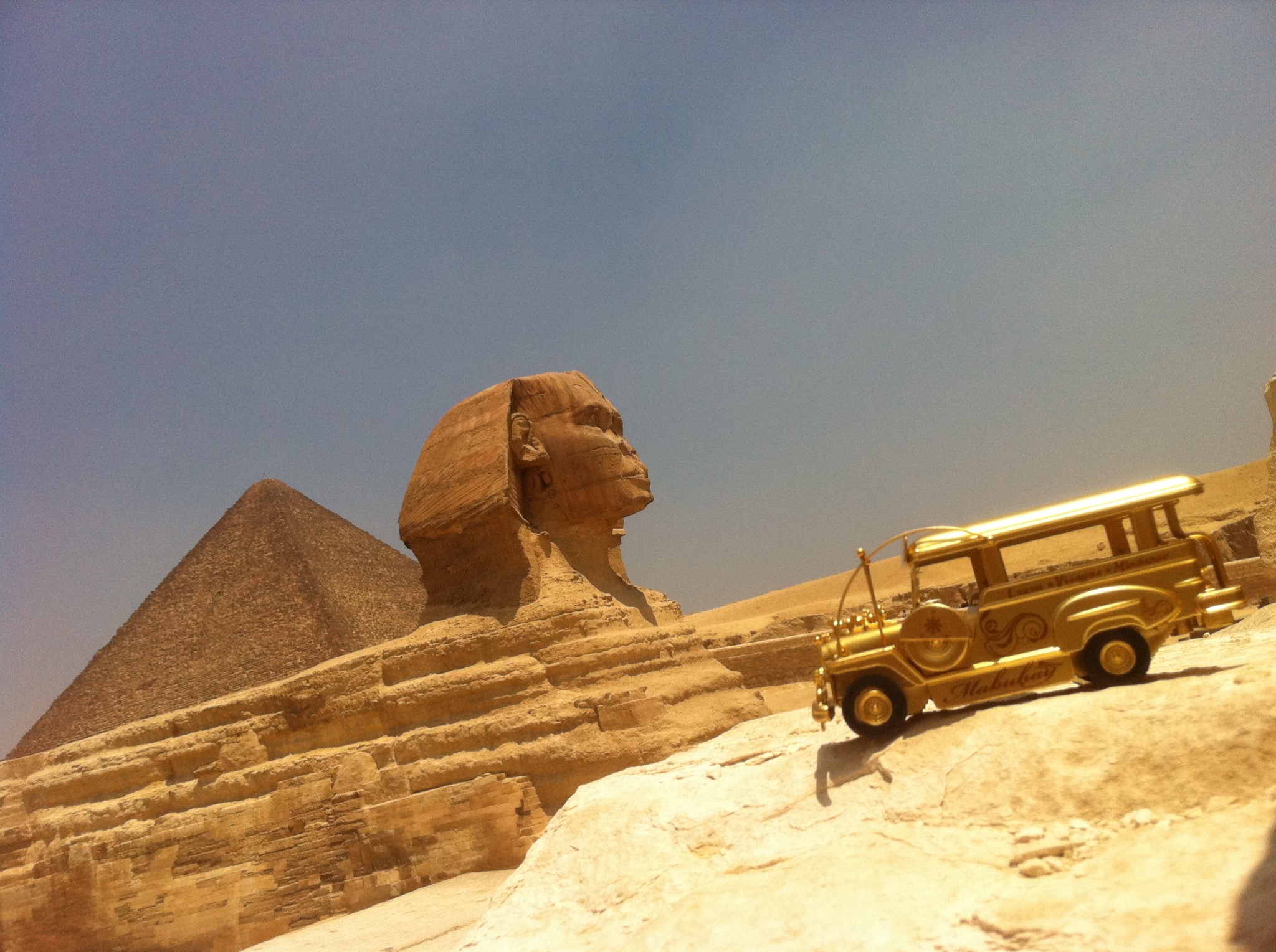 Golden jeepney posed before the Great Sphinx and a pyramid at Giza