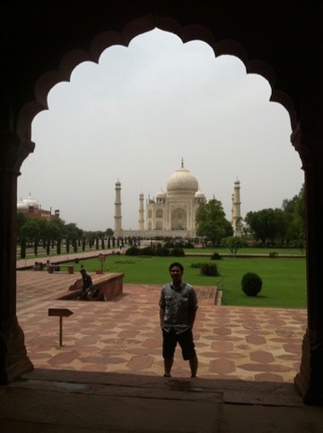 Traveler framed by an arch at the Taj Mahal