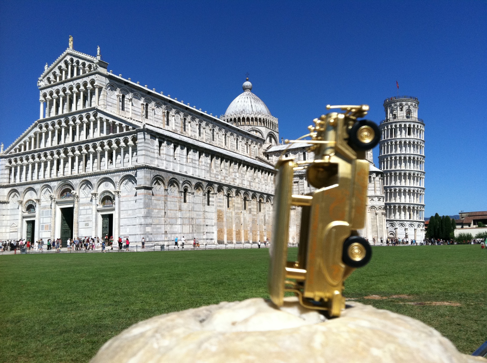 Golden jeepney posed upright before Pisa Cathedral and the Leaning Tower