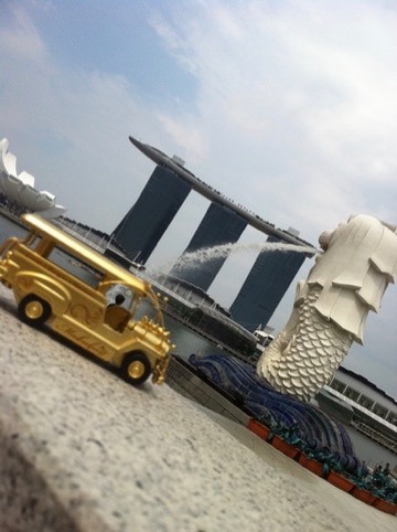 Golden jeepney with the Merlion and Marina Bay Sands